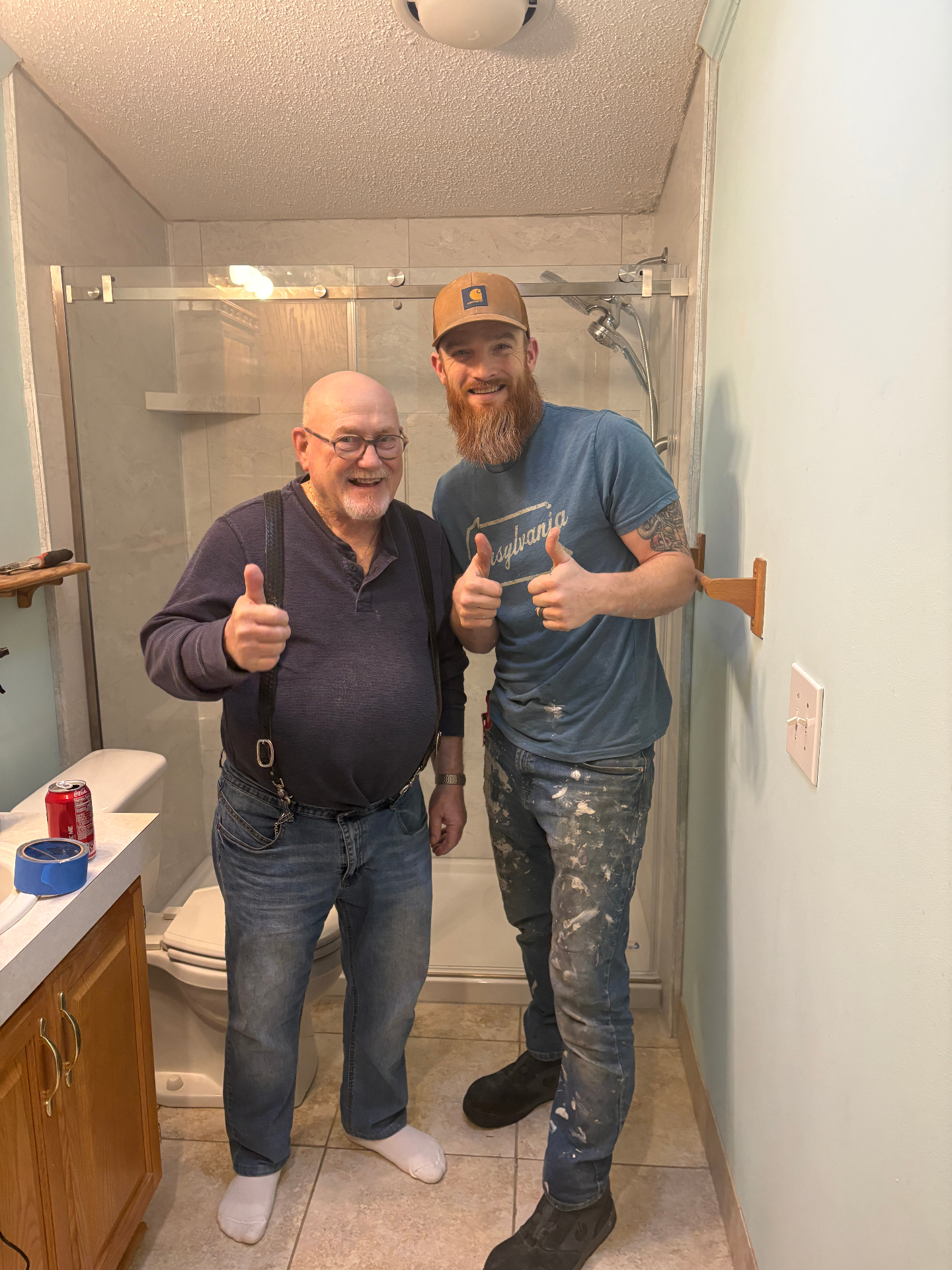 Rare Gem owner Brandon with a happy client giving thumbs up in a finished bathroom